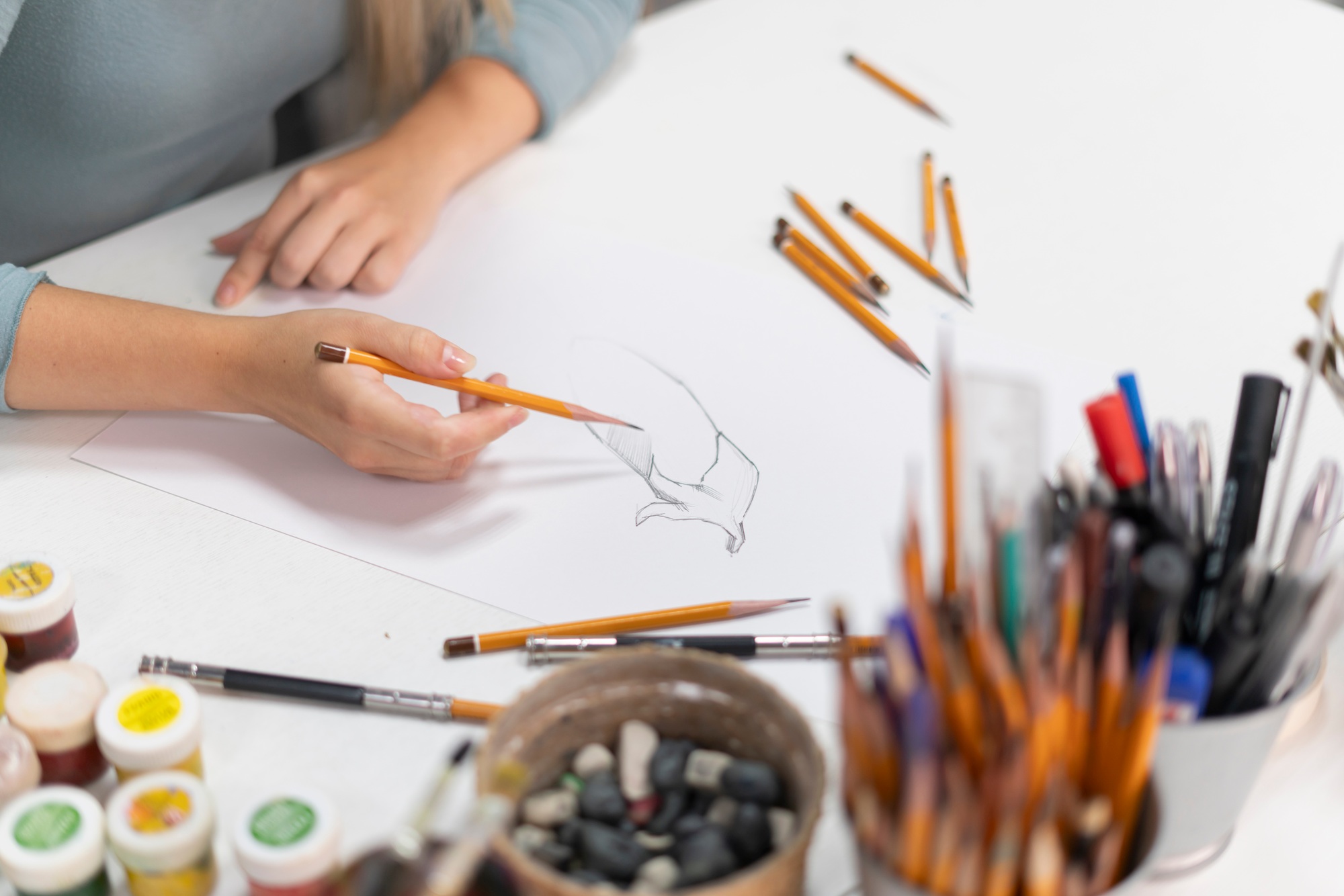 a young female artist drawing cartoon on a paper with pencil